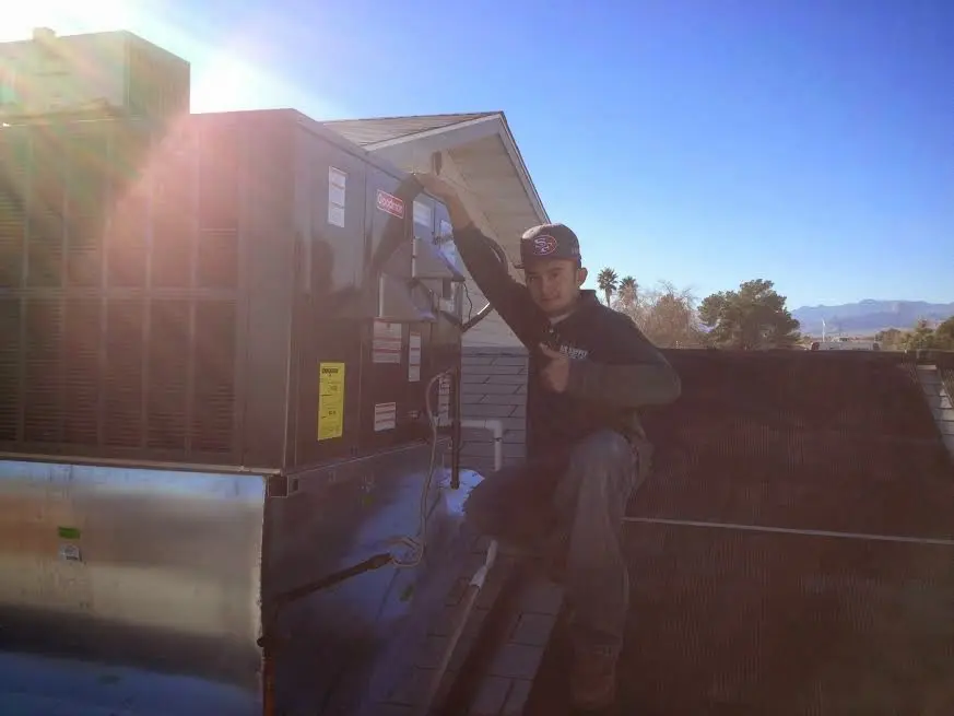 HVAC technician performing AC Tune-Up on a rooftop unit in Shallotte
